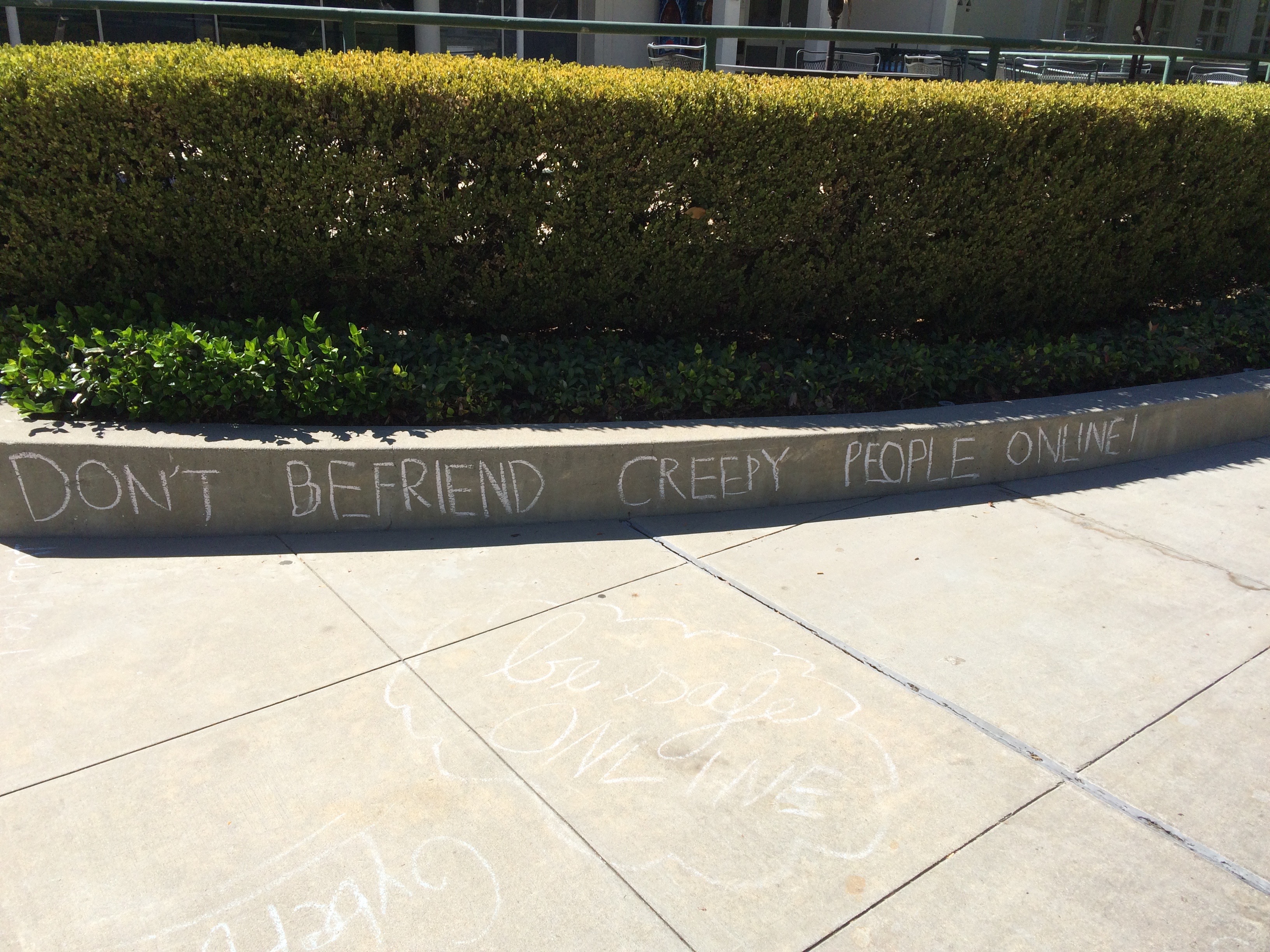 "Don't befriend creepy people online," says a chalk text.